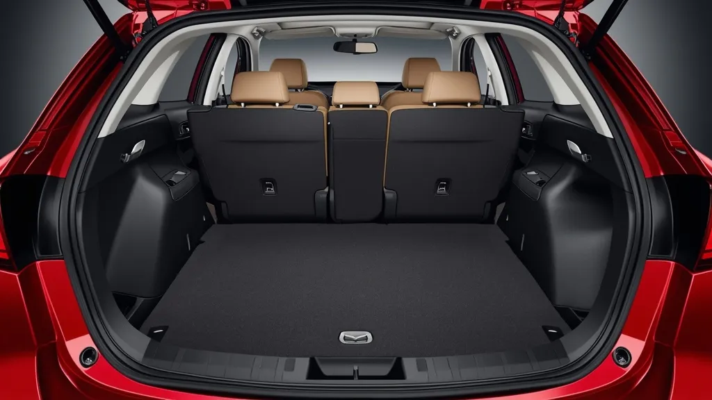 Spacious cargo area of a 2013 Mazda 3 hatchback with folded seats, demonstrating versatility.